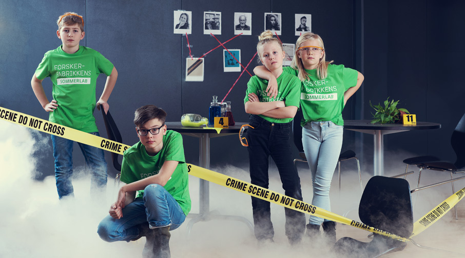 fire barn i grønne t-skjorter i et rom med gule sperrebånd med tekst "crime scene - do not cross"